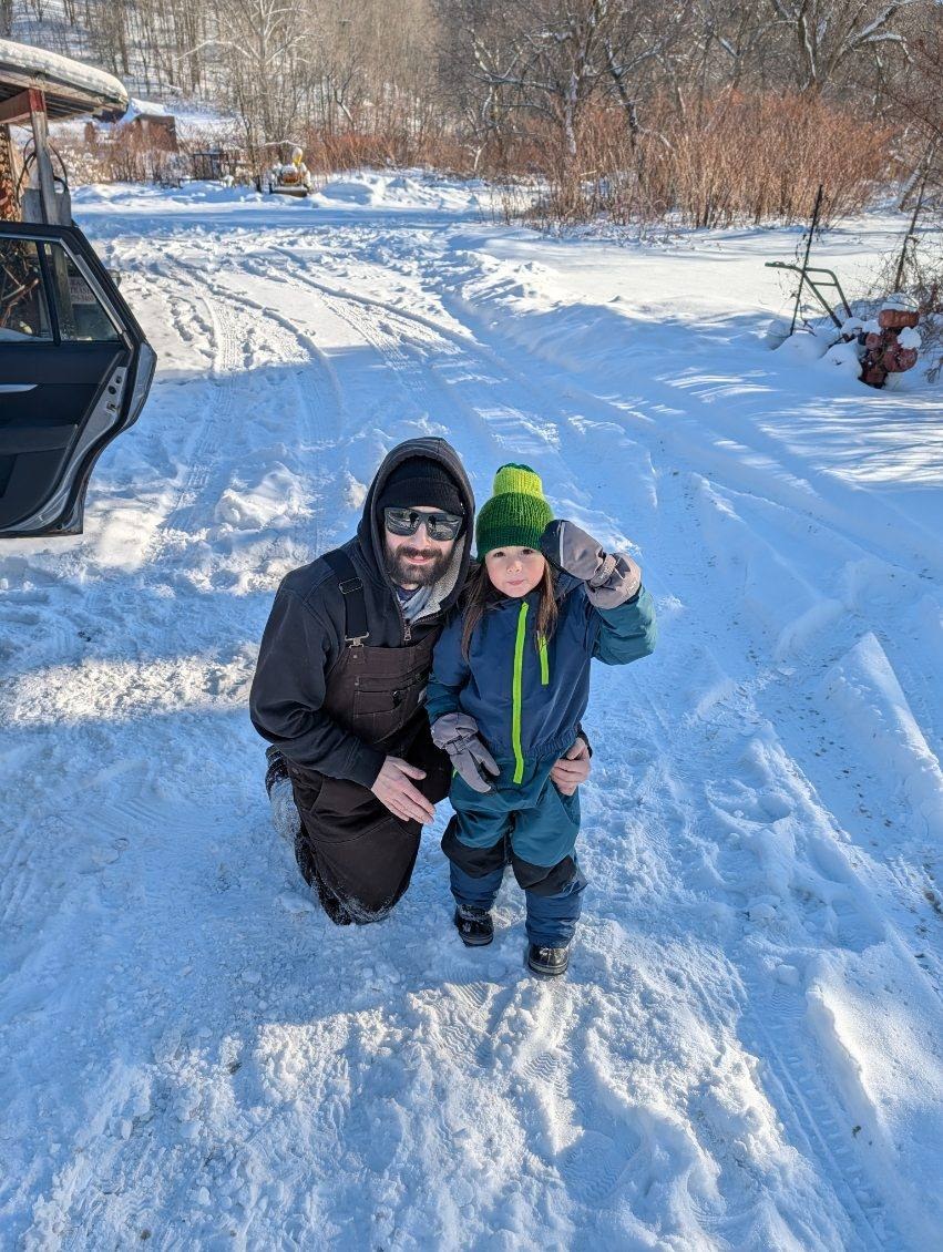 Max and his son Logan standing together in the snow in Vermont